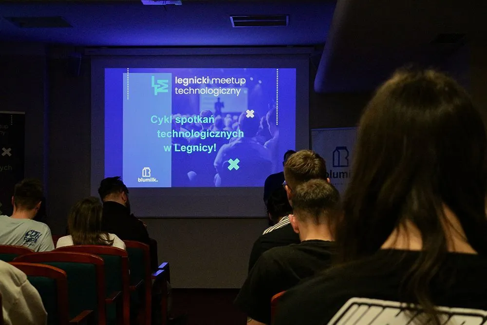 Audience viewing a presentation at a Legnica Tech Meetup.